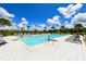 Community pool with people swimming and lounge chairs at 3803 Savanna Palms Ct, Bradenton, FL 34211