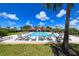 Resort-style pool with lounge chairs for relaxation, surrounded by palm trees and a bright blue sky at 3803 Savanna Palms Ct, Bradenton, FL 34211