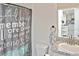 Bathroom with granite countertop, stylish shower curtain, and view into the kitchen at 3813 Lively Coral Pl, Bradenton, FL 34208