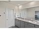 Bathroom with double granite vanity, neutral walls, and large mirror over the length of the vanity at 3813 Lively Coral Pl, Bradenton, FL 34208