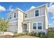 Side view of a two-story home with a gray exterior, manicured lawn, and a two-car garage at 3813 Lively Coral Pl, Bradenton, FL 34208