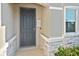 Close-up of a gray front door with stone accents and a welcoming 'Welcome' sign at 3813 Lively Coral Pl, Bradenton, FL 34208