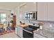 Kitchen featuring granite counters, stainless appliances, and gray cabinets, open to the dining area at 3813 Lively Coral Pl, Bradenton, FL 34208