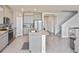 Kitchen with gray cabinets, stainless appliances, a large island, and an open concept to the staircase at 3813 Lively Coral Pl, Bradenton, FL 34208