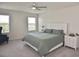 Main bedroom with ceiling fan, white nightstands, light gray walls, and neutral carpet at 3813 Lively Coral Pl, Bradenton, FL 34208