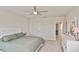 Bright primary bedroom with a ceiling fan, dresser, and access to the bathroom at 3813 Lively Coral Pl, Bradenton, FL 34208