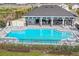 Aerial view of a refreshing community pool with a modern pool house and ample seating at 3813 Lively Coral Pl, Bradenton, FL 34208