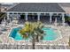 Aerial shot of the community pool featuring a modern pool house, barbecue and sun umbrellas at 3813 Lively Coral Pl, Bradenton, FL 34208