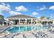 Beautiful community pool area with lounge chairs, shade umbrellas, and a modern pool house at 3813 Lively Coral Pl, Bradenton, FL 34208