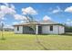 A backyard view of a white home with a screened in porch and a lush lawn at 3836 Wenona Dr, North Port, FL 34288