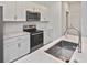 Modern kitchen with stainless steel oven and sink with marble countertops and white cabinets at 3836 Wenona Dr, North Port, FL 34288