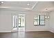 Bright living room with coffered ceilings, modern lighting, and a sliding glass door at 3836 Wenona Dr, North Port, FL 34288