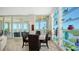Dining area features glass shelving, modern décor, and expansive windows offering scenic water views at 385 N Point Rd # 903, Osprey, FL 34229