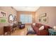 Cozy living room featuring hardwood floors, a comfortable sofa, and plenty of natural light from the window with shutters at 385 N Point Rd # 903, Osprey, FL 34229