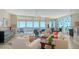 Spacious living room featuring floor-to-ceiling windows offering panoramic water views and stylish furnishings at 385 N Point Rd # 903, Osprey, FL 34229