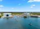 Aerial view featuring marina, waterfront buildings, and a boat sailing on the clear blue water at 388 Aruba Cir # 103, Bradenton, FL 34209
