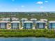 Scenic aerial view of waterfront condos surrounded by lush greenery and tranquil water at 388 Aruba Cir # 103, Bradenton, FL 34209