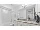 Bathroom with granite countertop vanity, large mirror and tub-shower combo featuring white marble style tile at 388 Aruba Cir # 103, Bradenton, FL 34209