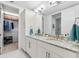 Elegant bathroom with double sinks, granite countertops, and a walk-in closet for ample storage at 388 Aruba Cir # 103, Bradenton, FL 34209