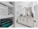 Bright bathroom features white cabinets, granite counters, and neatly organized open shelves with colorful towels at 388 Aruba Cir # 103, Bradenton, FL 34209