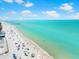 Expansive beach view with clear turquoise water, sunbathers and colorful umbrellas along the shoreline at 388 Aruba Cir # 103, Bradenton, FL 34209