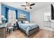 This bedroom boasts a ceiling fan and is decorated with blue accents, a bedside table, and a connected bathroom at 388 Aruba Cir # 103, Bradenton, FL 34209