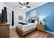 Bedroom featuring wood-look floors, blue accent wall, and coordinated decor creates a peaceful atmosphere at 388 Aruba Cir # 103, Bradenton, FL 34209