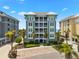 Beautiful exterior of a condominium building with multiple floors, balconies, and lush landscaping and palm trees at 388 Aruba Cir # 103, Bradenton, FL 34209