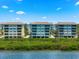 Exterior of waterfront condo buildings with tropical foliage and beautiful water view at 388 Aruba Cir # 103, Bradenton, FL 34209