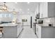 Modern kitchen with white cabinets, stainless steel appliances, granite countertops, and views of the living area at 388 Aruba Cir # 103, Bradenton, FL 34209