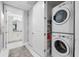 Convenient laundry area with stacked washer and dryer, plus shelving for storage near the hallway bathroom at 388 Aruba Cir # 103, Bradenton, FL 34209
