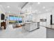 Open living area featuring a modern kitchen, a water view, and comfortable seating flowing from the outdoor balcony at 388 Aruba Cir # 103, Bradenton, FL 34209