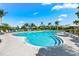 Community Pool with inviting blue water, lounge chairs and tropical landscaping at 388 Aruba Cir # 103, Bradenton, FL 34209