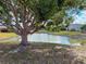 Scenic pond view with mature tree, rock embankment and blue sky reflected in the water, adding natural beauty to the landscape at 3909 40Th W St, Bradenton, FL 34205
