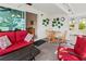 A cozy sunroom furnished with a red loveseat and chairs offers a relaxing seating area and table at 3909 40Th W St, Bradenton, FL 34205