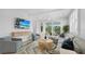 Cozy living room with stylish furniture, neutral tones, and a sliding glass door to the outdoors at 4206 Saltwater Pearl Way, Cortez, FL 34215