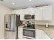 Bright kitchen with stainless steel appliances, granite counters, and white cabinets at 428 40Th W Ct, Palmetto, FL 34221