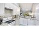 Bright kitchen features white cabinetry, stainless appliances, and granite countertops at 4640 Tower Hill Ln # 2325, Sarasota, FL 34238