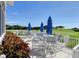Outdoor seating area overlooking the golf course, featuring tables with umbrellas for shade and comfortable seating at 4640 Tower Hill Ln # 2325, Sarasota, FL 34238