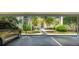 Assigned covered parking spot, with green space featuring flower beds, shrubs and young palms at 4640 Tower Hill Ln # 2325, Sarasota, FL 34238