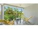 Screened-in porch with beautiful green views of lush tropical foliage and two Adirondack chairs at 4640 Tower Hill Ln # 2325, Sarasota, FL 34238