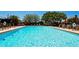 Community pool with comfortable lounge chairs under palm trees and a refreshing blue pool with safety buoys at 4640 Tower Hill Ln # 2325, Sarasota, FL 34238