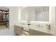 Bright bathroom features double sinks, a large illuminated mirror, and a walk-in closet for luxury and convenience at 4950 Remington Dr # 104, Sarasota, FL 34234