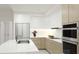 Bright kitchen boasts white and wood cabinets, stainless appliances, and marble countertops for a clean, modern aesthetic at 4950 Remington Dr # 104, Sarasota, FL 34234