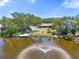 Expansive waterfront property with a private dock, fountain, and lush landscaping, ideal for serene living at 5024 37Th E St, Bradenton, FL 34203