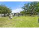 Large backyard with various outbuildings including beehives, a shed, and a treehouse, offering versatile outdoor space at 5024 37Th E St, Bradenton, FL 34203