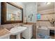 Well-lit bathroom with a pedestal sink, ornate mirror, and a tub/shower combination at 5024 37Th E St, Bradenton, FL 34203