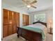 Cozy bedroom featuring wood floors, ceiling fan, and two closets with shuttered doors at 5024 37Th E St, Bradenton, FL 34203