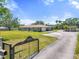 View of front exterior and lawn from the driveway and gate at 5024 37Th E St, Bradenton, FL 34203