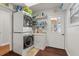 Bright laundry room featuring a stackable washer and dryer, utility sink, and ample storage space on shelves at 5024 37Th E St, Bradenton, FL 34203